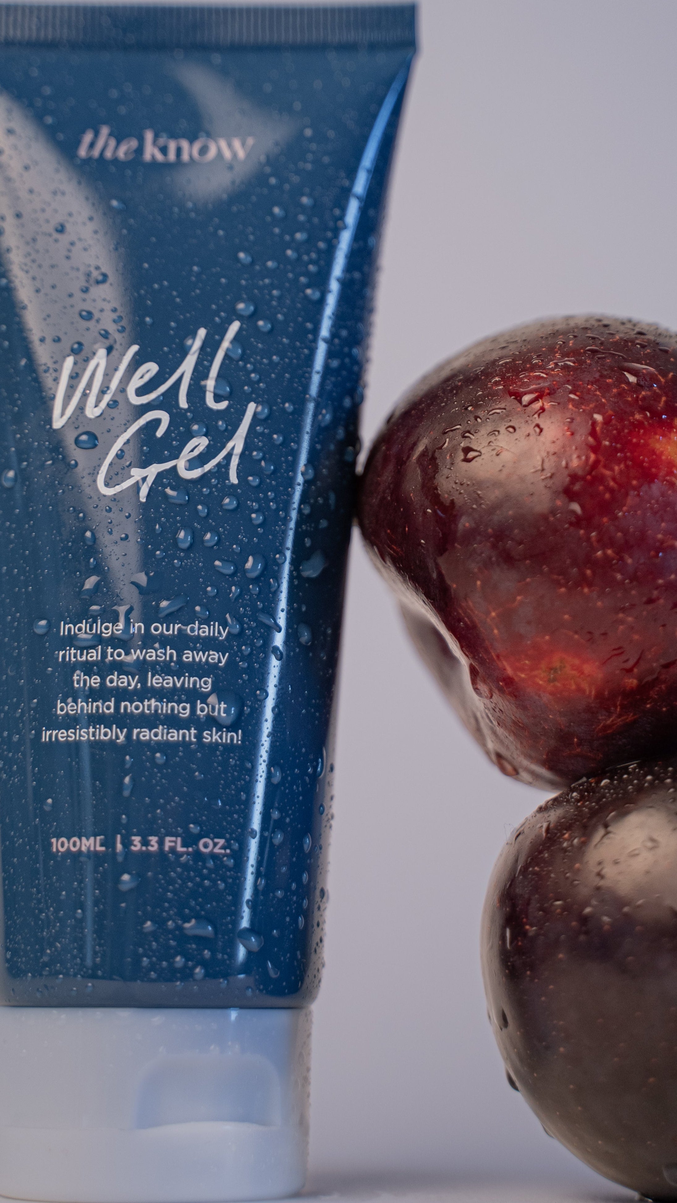 Blue tube labeled 'the know Well Gel' with two dark red fruits on a light gray background